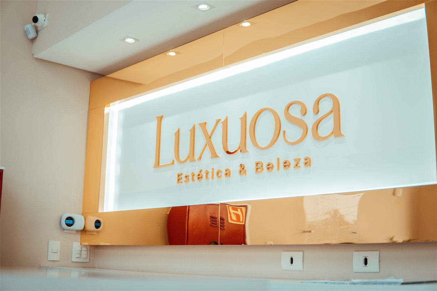 Recepção da Luxuosa com o painel iluminado e o logo dourado